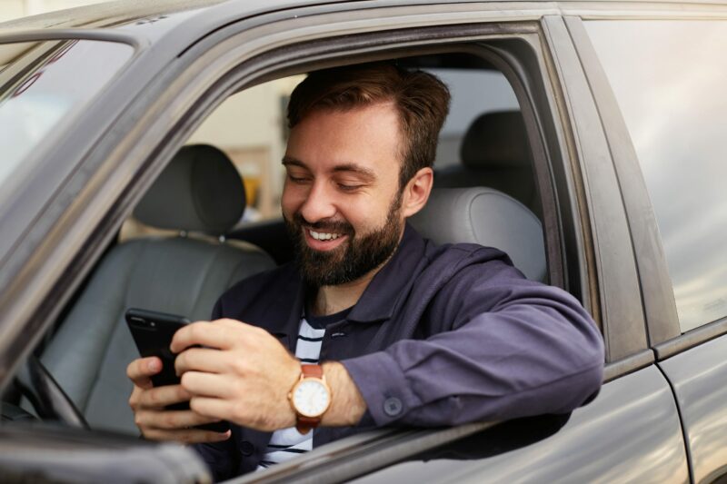 mileage logbook created by a happy man using a mileage tracker app in car