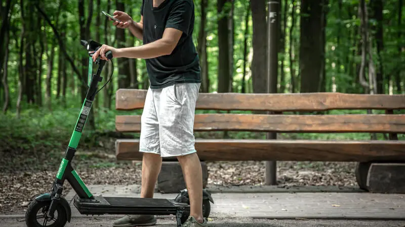 Lime Scooter charger collecting a drained scooter in a park