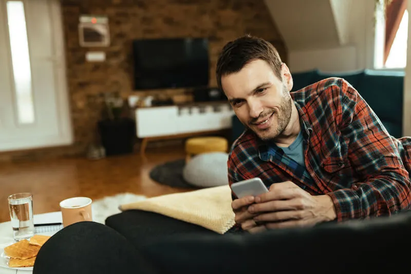 man reads MileageWise's top 10 blogs on his cellphone from home