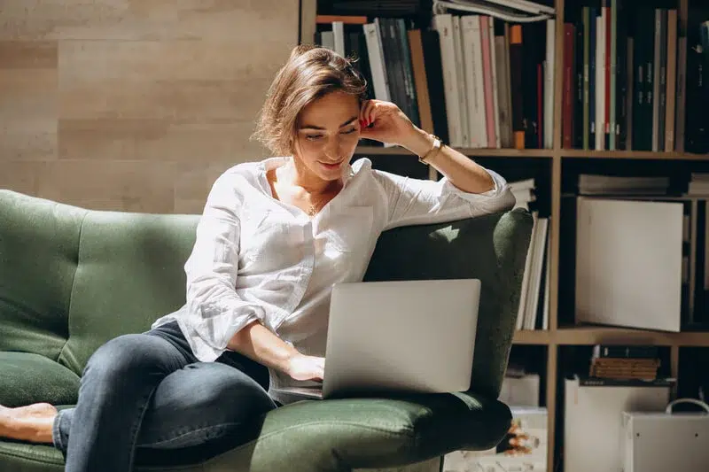 woman reads MileageWise's top 10 blogs on her laptop from home